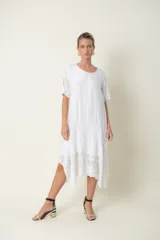 Vestido blanco de seda con mangas cortas y bajo con detalles de broderie.