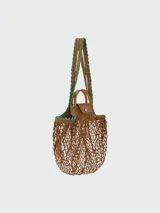 Bolso tipo shopper de red con diseño de malla, con solapa y asas de cuero marrón. Incluye un pañuelo estampado decorativo en uno de los laterales.