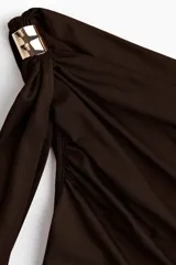 Top color marrón de punto elástico, con un hombro descubierto y una tira larga que cae desde el hombro. Presenta fruncidos en los laterales para un efecto drapeado.