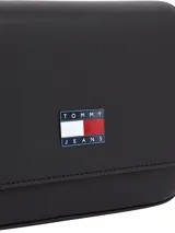 Cartera bandolera Tommy Jeans de color negro, confeccionada en poliuretano con acabado liso, solapa magnética frontal y el parche distintivo de la marca en el centro.