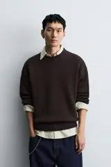 Jersey de corte relajado confeccionado en tejido de algodón. Presenta cuello redondo, manga larga y acabados en rib en puños, cuello y bajo.