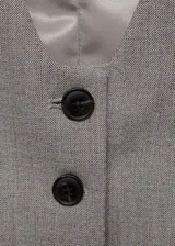 Chaleco de estilo sastre con diseño crop, cuello de pico y cierre frontal de botones. Presenta dos bolsillos de ribete en la parte delantera y cuenta con forro interior.