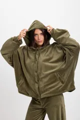 Campera de terciopelo color chocolate, con corte holgado, mangas murciélago y capucha desmontable. Presenta cierre frontal con botones a presión y bolsillos laterales.