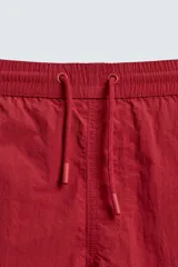 Bañador de hombre color azul marino, confeccionado en tejido técnico, con cintura elástica ajustable mediante cordón. Presenta bolsillos laterales y un bolsillo trasero de plastrón. Incluye forro interior.
