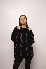 Buzo tejido a mano con lana merino color negro y bordado con ochos en color blanco y rojo.