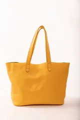 Bolso tote de cuero color tostado, con doble asa de hombro y diseño minimalista. Incluye un bolsillo separador extraíble.