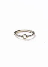 Anillo de plata 925 con baño de oro 18k, presenta un diseño central de círculo liso y laterales decorados con pequeñas zirconias incrustadas.