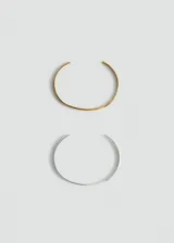 Pack de dos pulseras rígidas abiertas de acero inoxidable, una en tono dorado y otra en tono plateado, de diseño minimalista.