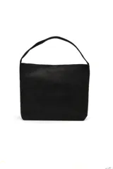 Cartera tipo tote de gamuza negra con asa única de hombro y diseño minimalista.