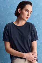 Remera negra de calce amplio, confeccionada en algodón liviano, con cuello redondo, mangas cortas y hombros levemente caídos.