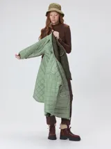 Campera reversible capitoneada con cierre frontal. Un lado es de color negro y el otro es de color beige, ambos con diseño acolchado. Cuenta con cuello redondo, mangas largas y bolsillos laterales.