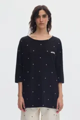 Vestido corto negro con estampado de lunares blancos, escote redondo y mangas 3/4.