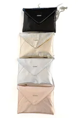 Sobre de mano tipo clutch confeccionado en charol negro brillante con solapa geométrica y cadena metálica plateada delgada.