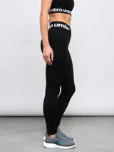 Calza deportiva Umbro modelo Legging Bink para mujer, de color negro, con cintura alta cruzada y elástica con la marca estampada.