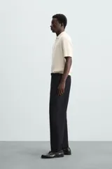 Polo de manga corta, color azul medio, tejido en punto perlado con cuello solapa y cierre frontal de cremallera.