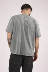 Remera de manga corta, corte oversize, color gris oscuro con efecto lavado o acid wash.