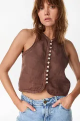 Top musculosa amarillo de lino italiano, con cuello redondo y cierre frontal de botones de nácar.