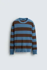 Jersey de punto de algodón con ajuste relajado, cuello redondo y manga larga. Presenta un diseño de rayas horizontales en azul y marrón, con detalles de efecto desgastado y roturas en el cuello, puños y bajo.