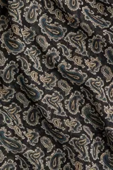 Blusa de gasa transparente con estampado paisley en tonos verde, beige y negro. Presenta cuello alto con moña, abertura en V frontal, frunces en los hombros, mangas globo largas y puños abotonados.