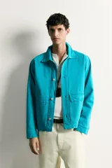 Cazadora relaxed fit de denim de algodón color turquesa, con cuello solapa, manga larga con puño abotonado, bolsillos frontales con solapa y cierre de botones metálicos.
