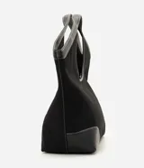 Cartera shopper grande de color negro, confeccionada en poliéster con detalles en material sintético en las esquinas inferiores y en las asas integradas. Cuenta con costuras pespunteadas a contratono y una estructura amplia con abertura superior con cierre.