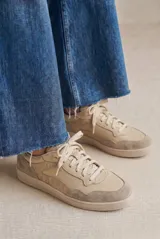 Zapatilla de cuero legítimo en tonos beige, con diseño combinado que incluye paneles de cuero liso, cuero con textura de reptil y detalles de gamuza en la puntera y el talón. Cuenta con cordones al tono y suela de goma.