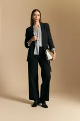 Pantalón negro de corte recto y tiro alto, con caída limpia y estructura en algodón con elastano.