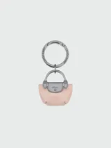Llavero Longchamp con diseño en miniatura de la icónica cartera Le Pliage, confeccionado en cuero color rosado con herrajes metálicos oscuros y logo grabado.