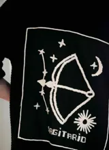 Sweater tejido en algodón color crudo, con bordado del signo zodiacal Cáncer en el frente. Diseño oversize de talle único.