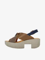 Sandalia de cuero con tiras cruzadas, base de goma espuma esculpida y hebillas metálicas.