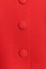Chaqueta corta de punto color azul marino, de cuello redondo, manga por debajo del codo y cierre frontal con botones forrados al tono.