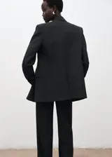 Chaqueta sastre gris oscuro con doble botonadura, cuello con solapa de muesca, bolsillos laterales con solapa y manga larga.