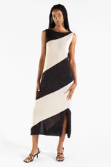 Vestido midi tejido bicolor en negro y beige con brillo sutil, escote bote, diseño sin mangas y abertura lateral en el dobladillo.