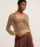 Blusa de punto color dorado con cuello polo, mangas largas y diseño calado.