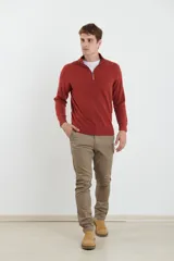 Sweater verde oliva de tejido acrílico con textura similar al cashmere, corte clásico, cuello alto con cierre metálico y tirador de cuerina ecológica.