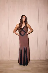 Vestido largo negro con estampado de lunares blancos, confeccionado en jersey con lurex y encaje. Presenta escote en V profundo, tirantes finos y detalles de encaje en el pecho y el ruedo.