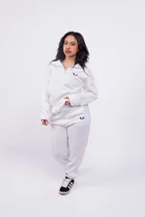 Pantalón de jogging color beige con cintura elástica y logo estampado en blanco en el muslo.