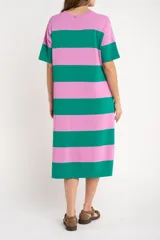 Vestido midi de tejido suave y ligero, con cuello redondo y mangas cortas. Presenta un patrón de rayas horizontales anchas en color verde oscuro y rosado. El vestido tiene aberturas laterales en el ruedo.