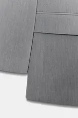 Blazer de cuello solapa y manga larga, con bolsillos delanteros con solapa y cierre frontal de un botón. Presenta un diseño estructurado con forro interior.