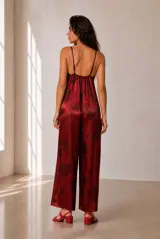 Mono largo bordó de satén con estampado sutil, escote en V con detalle en contraste y tirantes finos ajustables. Presenta pantalón de corte amplio y holgado.