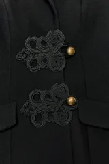 Mono negro de cuello halter con solapas, espalda descubierta y cierre frontal de botones con alamares.