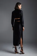 Vestido midi negro de satén con escote en V, corte cruzado con lazo en la cintura y mangas largas.