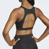 Top deportivo negro de soporte medio, con escote redondo, espalda abierta y tejido texturizado con logo Adidas grande en el frente.