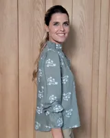 Blusa de algodón con cuello mao y volados, mangas largas con puños elásticos y corte holgado.