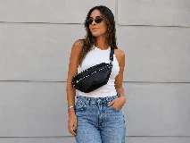 Riñonera de cuero color negro, con múltiples compartimentos con cierre metálico, detalles de tachas en los laterales y correa regulable.