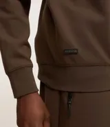 Buzo deportivo color verde claro, de manga larga y cuello redondo. Confeccionado en tejido de poliéster, viscosa y elastano.