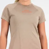 Remera deportiva color beige con logo New Balance estampado en naranja en el pecho.