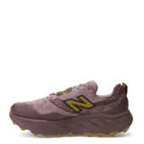 Championes de trail running New Balance Hierro V9 para mujer, en color malva con detalles en mostaza y suela de goma marrón. Confeccionados con malla técnica transpirable y entresuela Fresh Foam X.
