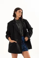 Blazer negro de corte oversize con solapas clásicas, cierre frontal de doble botonadura y bolsillos laterales con solapa.