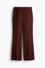 Pantalón acampanado de color bordó, de talle alto con pretina prolongada y cierre oculto. Presenta bolsillos al bies en los laterales, bolsillos decorativos en la parte trasera y perneras amplias con pliegues marcados tanto en el frente como en la espalda.